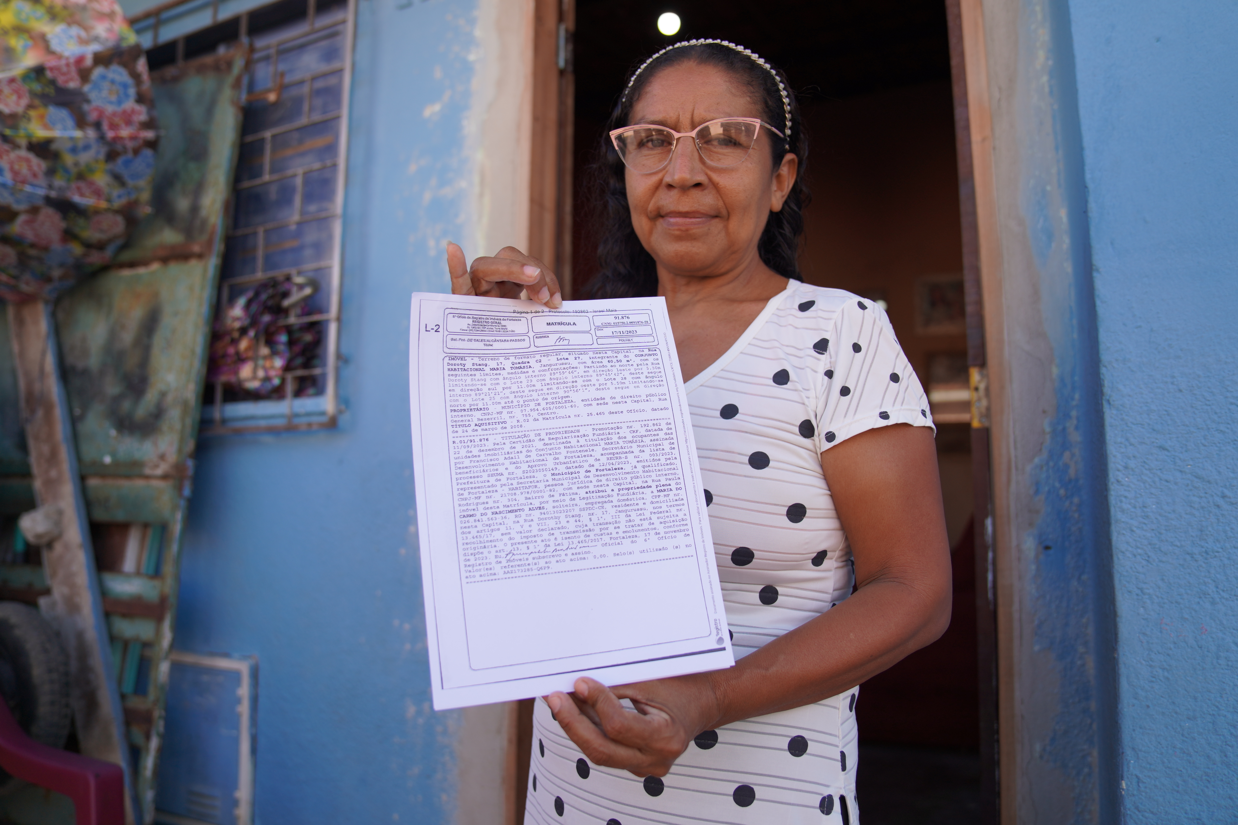 mulher segura o documento do papel da casa em frente a sua residência